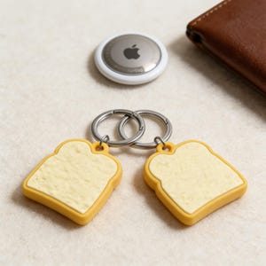 May include: A white ceramic mug with a black handle and the text "But First, Coffee" in a black, handwritten-style font. The mug is on a white surface.