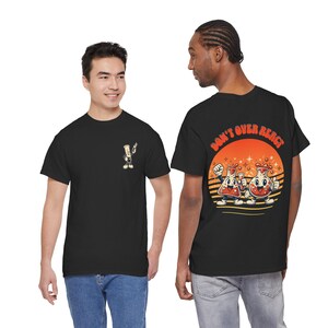 May include: Black t-shirts with cartoon graphics. One shirt has a small beaker graphic on the front. The other has a larger graphic on the back with two beakers and the text "DON'T OVER REACT" in orange.