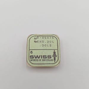 Könnte beinhalten: Eine kleine, rechteckige, hellgrüne Verpackung mit schwarzem Text. Der Text enthält "NoS-05076", "Flo0 NG.30 L" und ".30 LS". Die Verpackung trägt auch das Wort "SWISS" und "IMPORTED OF SWITZERLAND".