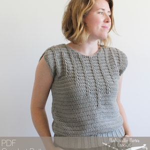 May include: A gray crochet top with a round neckline and short sleeves. The top is made with a textured stitch pattern. The text "Naturally Nora Crochet" is visible in the lower right corner of the image.