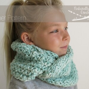 May include: A young person wearing a teal blue crocheted cowl neck scarf. The scarf is made with a textured stitch pattern. The text "PDF Crochet Pattern" and "Naturally Nora Crochet" is visible in the image.