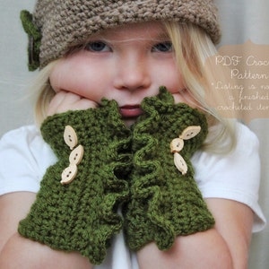 Puede incluir: Un niño lleva un gorro de punto marrón y guantes sin dedos de ganchillo verde con botones de madera. Los guantes tienen un borde rizado. El texto "PDF Crochet Pattern *Listing is not for a finished crocheted item.*" es visible en la imagen.