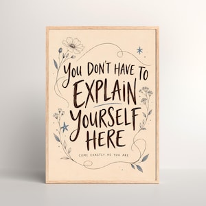 May include: A rectangular framed wall art print on a cream background featuring the dark brown text "YOU DON'T HAVE TO EXPLAIN YOURSELF HERE" and "COME EXACTLY AS YOU ARE" surrounded by delicate line-drawn floral illustrations and small blue stars.