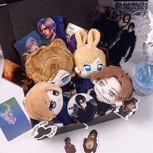 May include: A collection of four plush dolls with embroidered facial features, accompanied by several character cards, a circular pin featuring a male figure, and various stickers including one with the text "STUPID MAN THING" inside a black box.