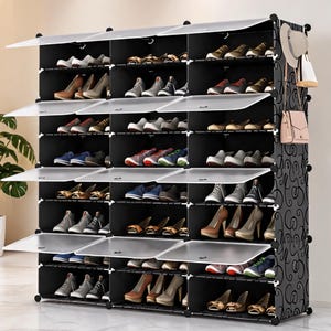 May include: A large black shoe organizer with multiple compartments and white hinged doors. The organizer is filled with various shoes, including sneakers, heels, and flats. A decorative side panel with a swirl pattern adds a stylish touch.
