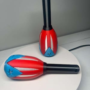 May include: Two decorative bottle stoppers featuring the Puerto Rican flag design. The stoppers have a red and blue design with white accents and a black handle. The star and stripes are visible on the stoppers.