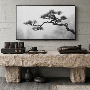 Può includere: Una lunga panca rettangolare in pietra dalla consistenza grezza e naturale funge da tavolo console. Sopra si trovano un amplificatore a valvole nero, una tazzina su un vassoio, un giradischi nero e un vaso scuro con erba secca. Un televisore a parete mostra un'immagine in bianco e nero di un ramo di pino.