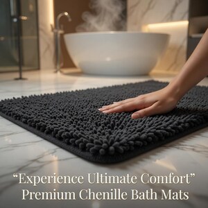 May include: A dark grey chenille bath mat with a textured surface. The mat is rectangular and has rounded corners. The text "Experience Ultimate Comfort" and "Premium Chenille Bath Mats" is visible.