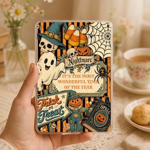 Puede incluir: Una funda de teléfono transparente con un diseño de Halloween, rayas naranjas y negras, una calavera, un fantasma, una telaraña, un espantapájaros, calabazas, maíz dulce y un libro de hechizos. El texto dice: Nightmare, IT'S THE MOST WONDERFUL TIME OF THE YEAR, Trick or Treat.