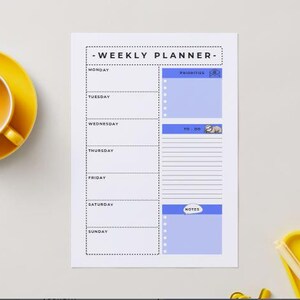 Könnte beinhalten: Ein weißer Wochenplaner mit dem Text "WEEKLY PLANNER" oben. Der Planer hat Abschnitte für jeden Wochentag sowie Abschnitte für "Prioritäten", "Aufgaben" und "Notizen". Eine gelbe Tasse und Untertasse befinden sich links.