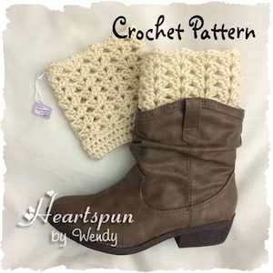 May include: A pair of crocheted boot cuffs in a cream colour. The cuffs are made with a simple stitch pattern and are shown on a brown boot.