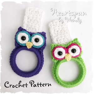 May include: Two crocheted owl pot holders, one purple with teal eyes and a white top, and one green with pink eyes and a white top. The text "Heartspun by Wendy" and "Crochet Pattern" are visible below the owls.