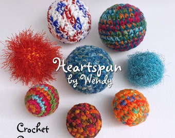 May include: A collection of colorful crocheted balls, including red, white, blue, green, orange, and brown. The balls are arranged on a white surface. The text "Heartspun by Wendy" and "Crochet Pattern" are also visible in the image.