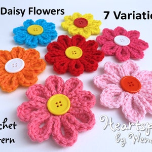 May include: Seven variations of crocheted 3-D daisy flowers in pink, red, orange, yellow, and blue with different colored buttons in the center. Crochet pattern by Heartspun by Wendy.