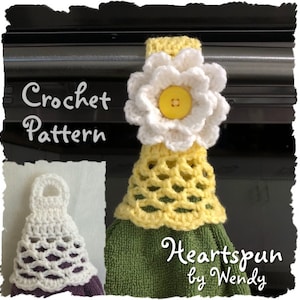 Può includere: Modello a uncinetto per un copri-asciugamano a forma di fiore giallo e bianco. Il copri-asciugamano è decorato con un fiore all'uncinetto con un bottone giallo al centro e un anello all'uncinetto per appenderlo.