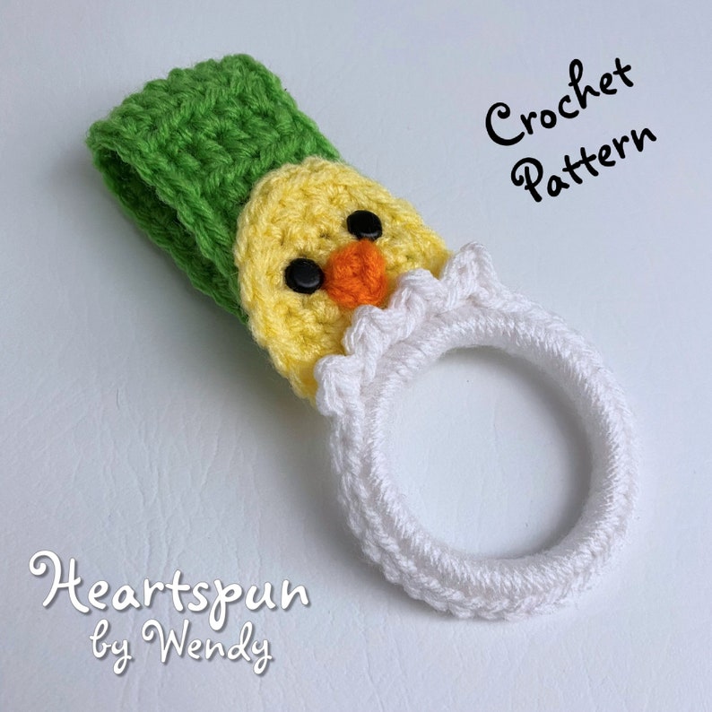 K&ouml;nnte beinhalten: H&auml;kelanleitung f&uuml;r ein gelbes K&uuml;ken mit gr&uuml;nem Hut und wei&szlig;em Ring. Das Muster hei&szlig;t "Heartspun by Wendy".