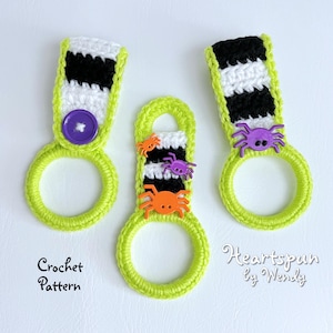 May include: Three crocheted green and black striped dish towels with a spider and button embellishments. The towels are labeled "Crochet Pattern" and "Heartspun by Wendy".