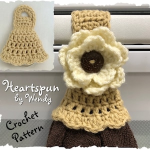 May include: Crochet pattern for a beige and white towel holder with a flower design. The pattern is called "Heartspun by Wendy".