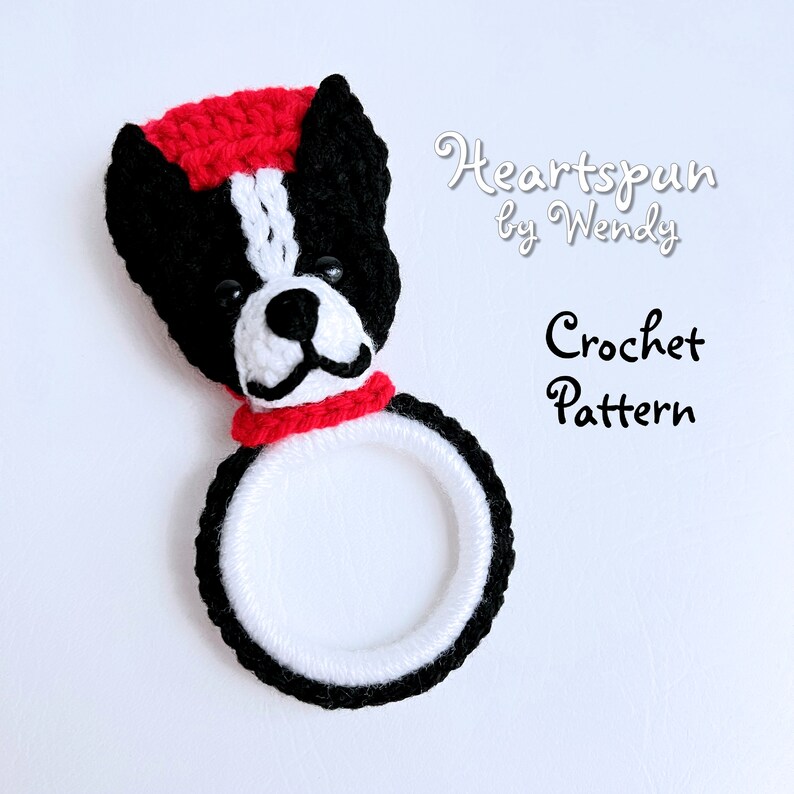 May include: Crochet pattern for a black and white dog with a red hat and scarf. The pattern is called "Heartspun by Wendy".