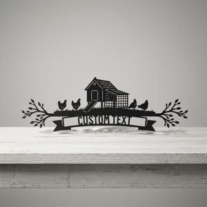Könnte beinhalten: Schwarzes Metallschild mit einem Hühnerstall, Hühnern und Ästen. Das Schild enthält den Text "CUSTOM TEXT" auf einem Banner. Das Design ist vor einem neutralen Hintergrund platziert, ideal für die Inneneinrichtung.