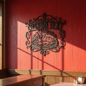Puede incluir: Arte de pared de metal negro con el texto "CUSTOM TEXT" encima de un dise&ntilde;o de parrilla con llamas. La pieza decorativa est&aacute; montada en una pared roja, con una mesa de madera y una ventana visibles en el fondo.
