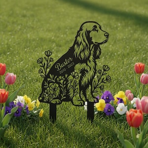 Può includere: Un picchetto da giardino in metallo nero con la sagoma di un cane spaniel circondato da motivi floreali. Il nome Buster e gli anni 2010-2023 sono incisi sul corpo del cane. Il picchetto ha due punte affilate nella parte inferiore.