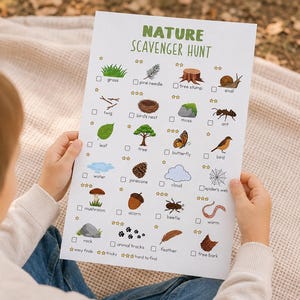 May include: A child holds a nature scavenger hunt checklist. The green text at the top reads "NATURE SCAVENGER HUNT." The checklist includes illustrations of grass, a pine needle, a tree stump, a snail, a leaf, a tree, a butterfly, and a bird.
