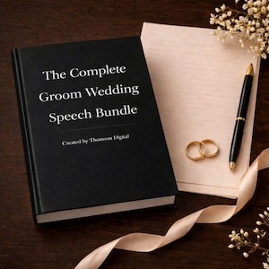 May include: A black book titled "The Complete Groom Wedding Speech Bundle" with white text. A gold pen, two gold wedding rings, and a notepad are on the right. A cream-colored ribbon and small white flowers are also present.