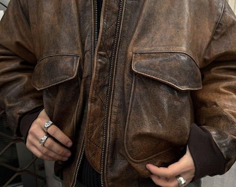 Chaqueta bomber de piel de oveja marrón envejecida, estilo aviador, con puños acanalados.