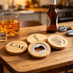 Puede incluir: Un juego de bar de madera con posavasos personalizados y un abridor de botellas. Los posavasos están grabados con nombres y un mensaje de celebración. También hay un vaso de líquido ámbar y una botella de cerveza.