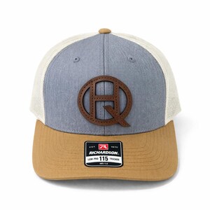 May include: A white ceramic mug with a black handle and the text "But First, Coffee" in a bold, black font. The mug is set against a blurred background, suggesting a cozy setting.