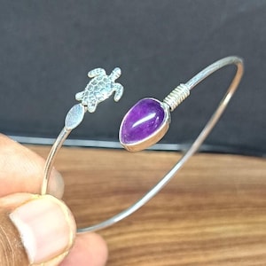 Pulseira artesanal em prata com tartaruga e ametista, leve e com fecho articulado de mola.