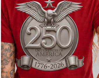 May include: A red t-shirt featuring the word FREEDOM on the front in a blue and white star-spangled and red and white striped font. The back displays a silver circular emblem with an eagle, the number 250, and the text UNITED STATES OF AMERICA 1776-2026.