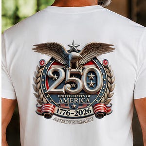 May include: A white t-shirt featuring the word FREEDOM in red, white, and blue lettering on the front. The back displays a graphic of a bald eagle above the number 250, with the text UNITED STATES OF AMERICA 1776-2026 ANNIVERSARY below it.