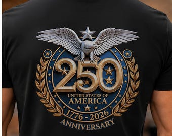 May include: A black t-shirt featuring the word FREEDOM on the front in a red, white, and blue flag pattern. The back displays a graphic of an eagle above the number 250, with the text UNITED STATES OF AMERICA 1776-2026 ANNIVERSARY.