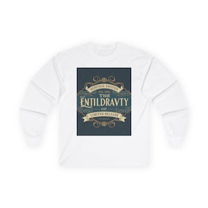 May include: White long-sleeve shirt with a rectangular graphic on the front. The graphic features the text "HERITAGE EDITION EST. 1992 THE ENTILDRAVTY CST LIMITED RELEASE" in a vintage style with gold and blue accents.