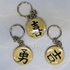 key chain 1.5 inch button with Japanese Kanjii Brave, Joy, Good Luck