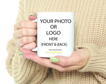 May include: A white ceramic mug held by a person. The mug has the text "YOUR PHOTO OR LOGO HERE (FRONT & BACK)". The mug is labeled "BEST SELLER IN MUG" with a five-star rating.
