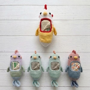 May include: Crocheted chicken-shaped tissue holders in various colors, including white, yellow, blue, pink, and green. Each holder has a rectangular opening for tissues and a loop at the bottom. The holders are displayed on a white wooden surface.