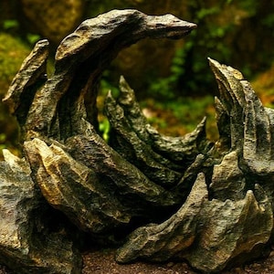 May include: A detailed, textured, and weathered decorative rock formation. The sculpture features a variety of jagged edges and a naturalistic color palette of browns and greens. The design evokes a sense of organic growth and natural beauty, suitable for home decor.
