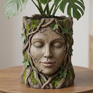 Puede incluir: Una maceta cilíndrica con forma de tronco de árbol que presenta un rostro humano con los ojos cerrados y una expresión serena. La superficie tiene un acabado de corteza texturizada, acentuada con parches de musgo y pequeñas hojas de hiedra.