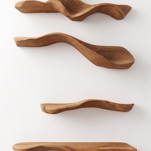 May include: Four individual wooden wall shelves arranged vertically. Each shelf features a distinct, organic, wavy silhouette with a natural light brown wood grain pattern, smooth rounded edges, and a carved, elongated form with a flat top surface.