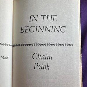 May include: A book titled "In the Beginning" by Chaim Potok.