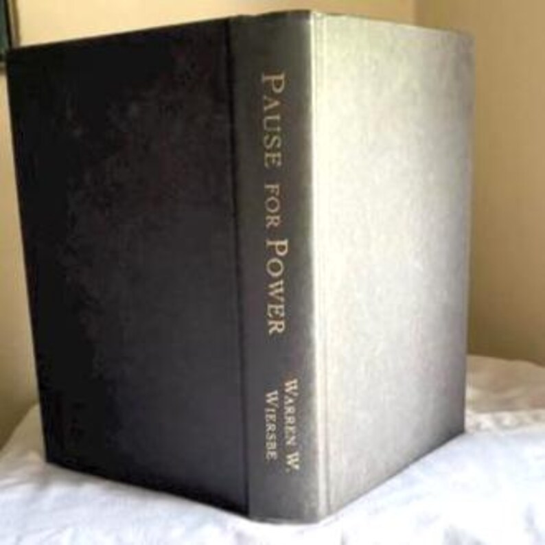May include: A hardcover book titled Pause for Power by Warren W. Wiersbe. The book features a dark, solid-colored cover with the title and author's name printed in a light, metallic-toned font vertically along the spine of the book.