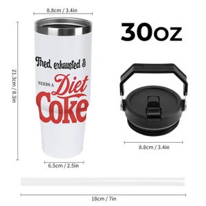May include: A white 30oz tumbler with a black lid and straw. The tumbler has the text "Tired, exhausted & NEEDS A Diet Coke" in black and red. The tumbler is 8.3 inches tall and 2.5 inches wide.