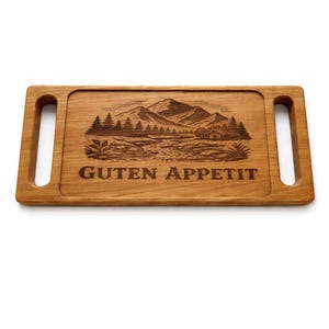 Può includere: Tagliere rettangolare in legno con scena di montagna e foresta intagliata e la scritta "GUTEN APPETIT". Il tagliere marrone chiaro ha due fori per le maniglie. Ideale per servire antipasti, misura circa 30 cm di lunghezza.