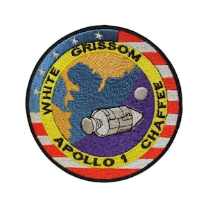 May include: Embroidered patch featuring the Apollo 1 mission emblem. The circular patch includes a map of North America, a spacecraft, and the names "Grissom, White, Chaffee." The design incorporates blue, yellow, red, and white colors.