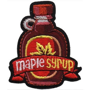 May include: Embroidered patch featuring a maple syrup bottle design. The patch is primarily red and brown, with yellow accents and the words "MAPLE SYRUP" in white. The bottle has a handle and a decorative leaf emblem.