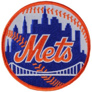 May include: A circular patch featuring the New York Mets logo. The design includes a blue skyline, the word "Mets" in orange, and baseball stitching. The patch has an orange border and a white background.