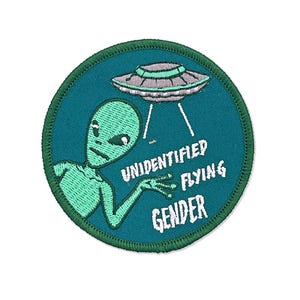 May include: Embroidered patch with a teal background and a green border. The patch features a green alien with a gray UFO and the words "UNIDENTIFIED FLYING GENDER" in white.